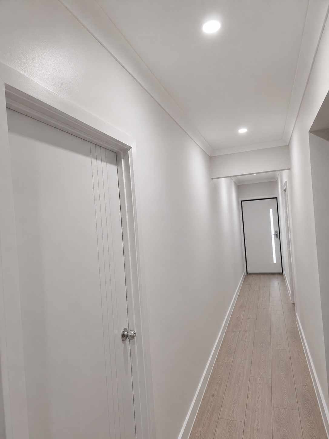 The finished hallway with freshly painted white walls, ceiling and trim